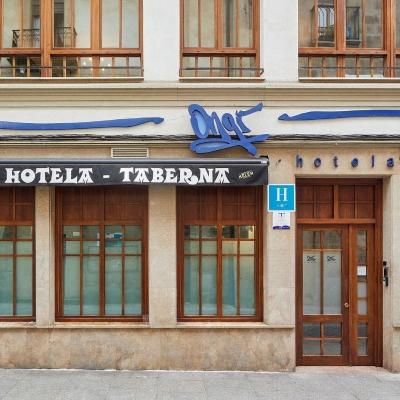 Fachada de un hotel y taberna con letrero y puerta de entrada
