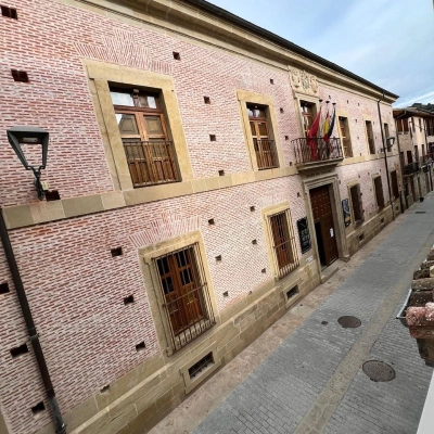 Calles y edificios de ladrillo con balcones y banderas al fondo