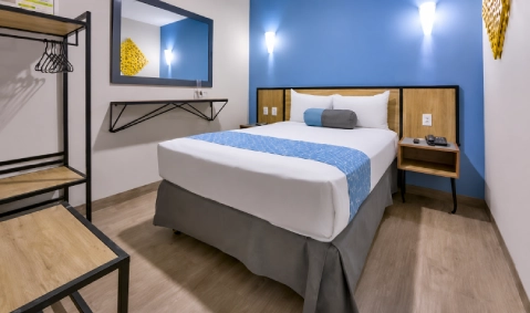 Dormitorio moderno con cama doble, mesita y luces azules decorativas