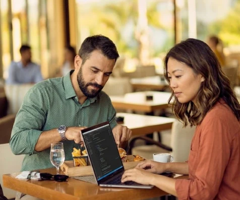 Pareja revisa un men&uacute; en una tablet en un restaurante.
