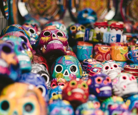 M&aacute;scaras coloridas tipo calavera en un puesto callejero, fondo con souvenirs