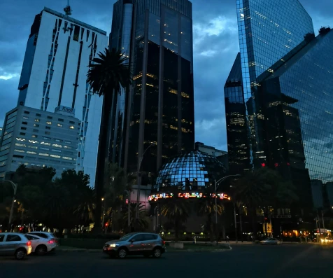 Rascacielos y palmeras frente a un edificio de oficinas al atardecer