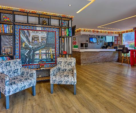 Sala de estar con muebles estampados y vitrina con cuadros azules.