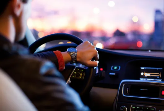 Conductor con las manos en el volante, vista nocturna de la carretera