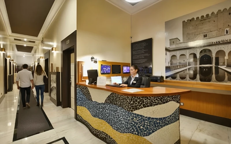 Recepci&oacute;n de museo con personal y paneles de informaci&oacute;n, en pasillo.