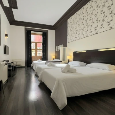 Interior de habitaci&oacute;n de hotel con dos camas y luz c&aacute;lida