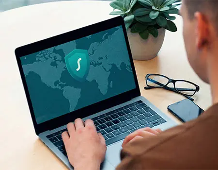 Persona usando port&aacute;til con icono de videollamada en el mapa del mundo