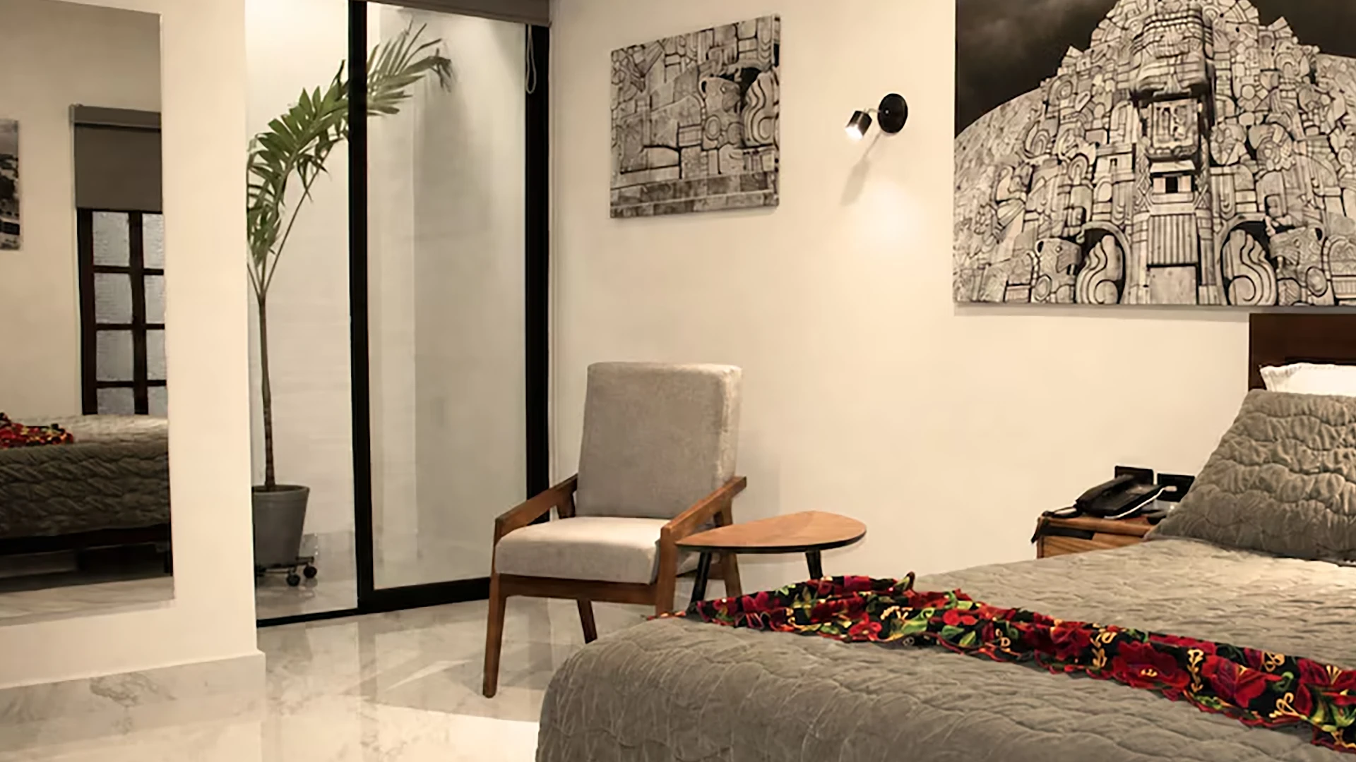 Dormitorio moderno con cama, silla, plantas y cuadros decorativos en la pared