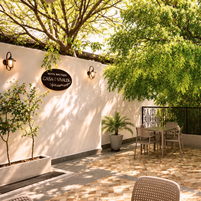 Patio del Hotel Boutique Casa Vivialdi con &aacute;rboles, plantas y mesa exterior