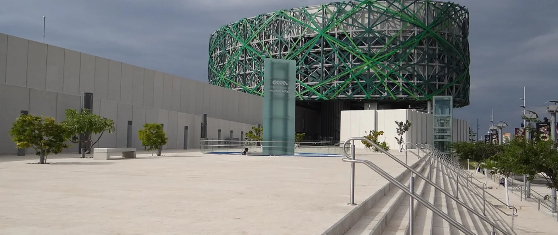 Pabell&oacute;n con c&uacute;pula geod&eacute;sica verde y escenario exterior, d&iacute;a nublado.