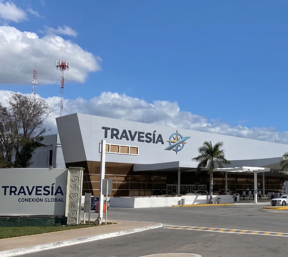 Fachada del edificio &ldquo;TRAVES&Iacute;A&rdquo; con el logo y un cielo azul con nubes