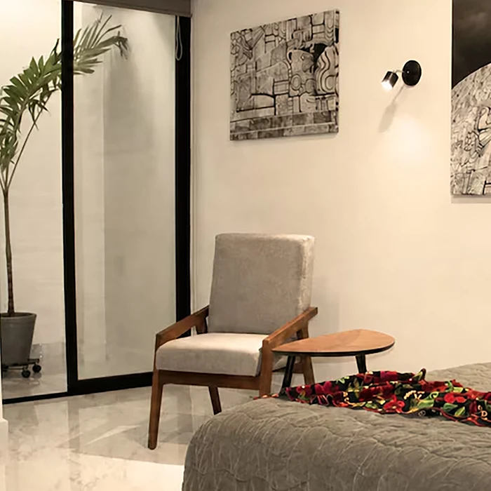 Interior moderno con sill&oacute;n gris, mesa oval y cuadros en pared.