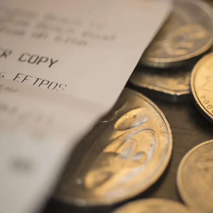 Monedas y billete desenfocados en primer plano con foco en las monedas.