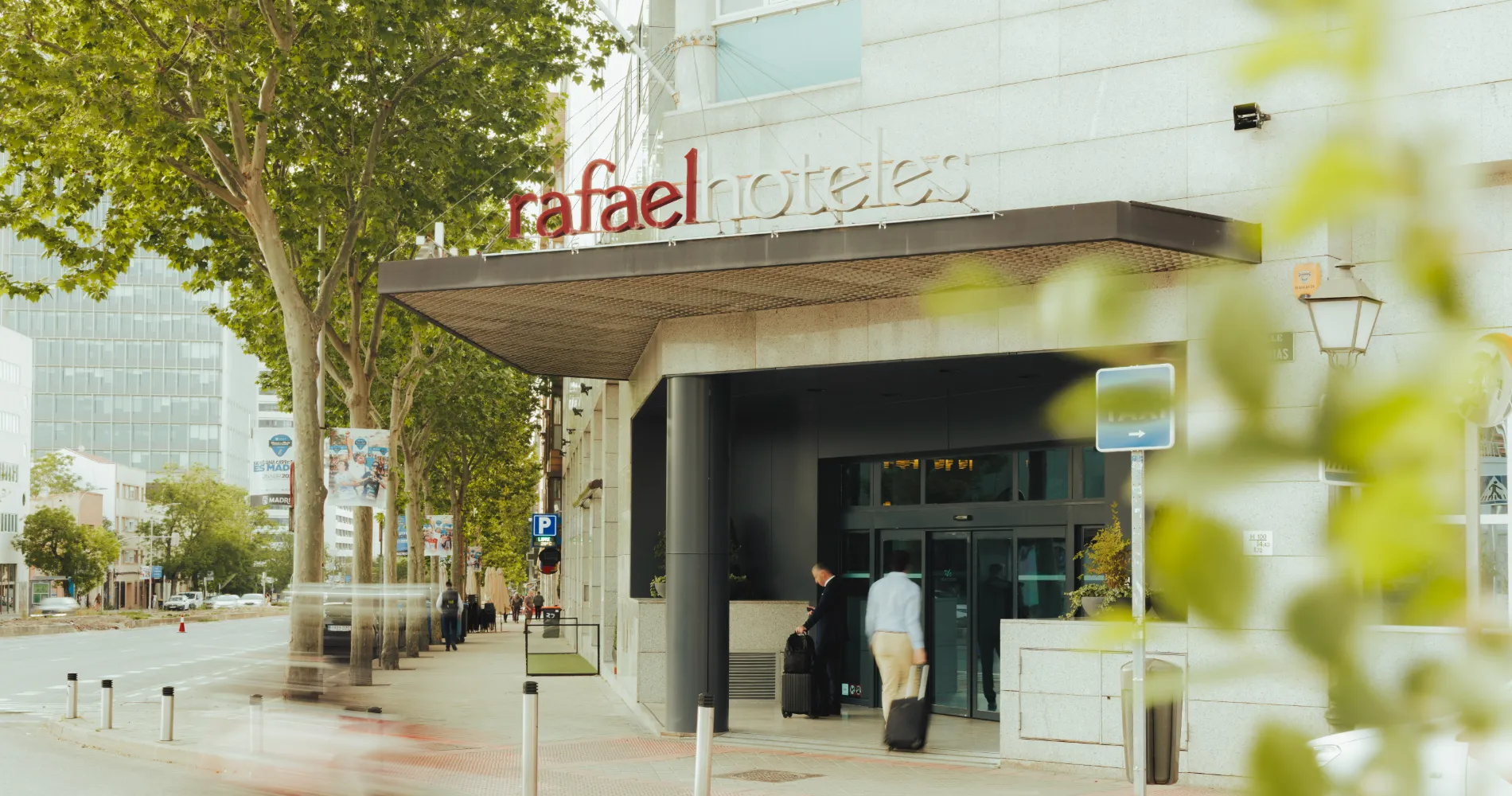 Entrada del hospital Rafaelhoteles con letrero &ldquo;rafaelhotels&rdquo; y peatones.