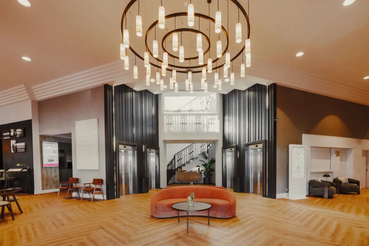 Sala moderna con lámpara colgante y elevadores de acero al fondo