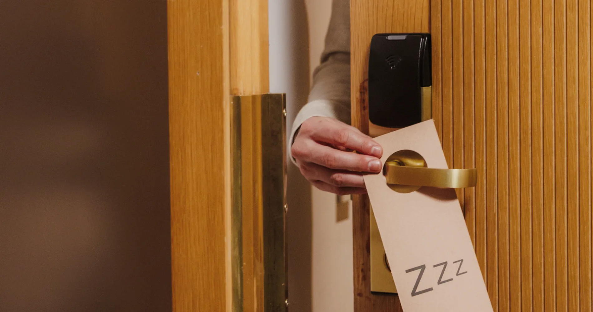 Mano de trabajador entregando una caja con la marca &ldquo;ZzZ&rdquo; en una puerta