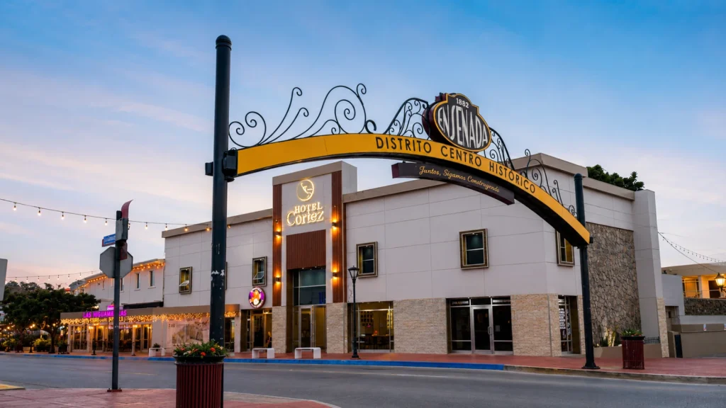 Entrada del Hotel Coraz&oacute;n &ldquo;Ensenada&rdquo;, con arco y letrero hist&oacute;rico al atardecer.