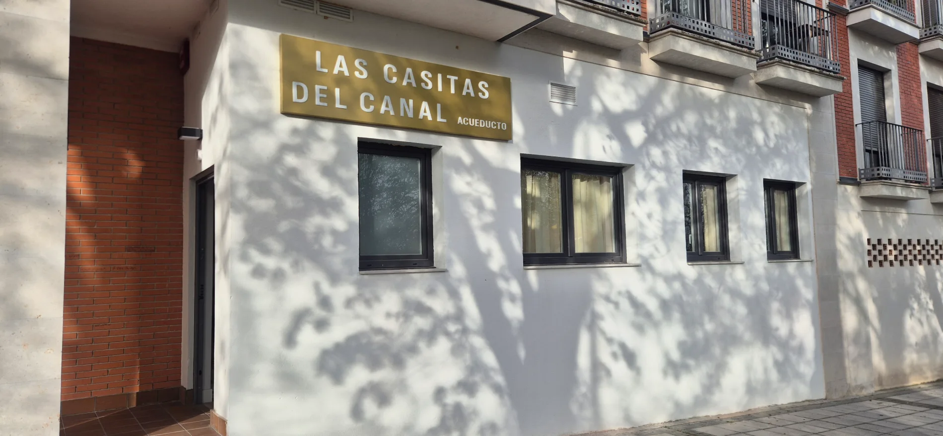 Fachada de edificio con letrero “Las Casitas del Canal” y ventanas