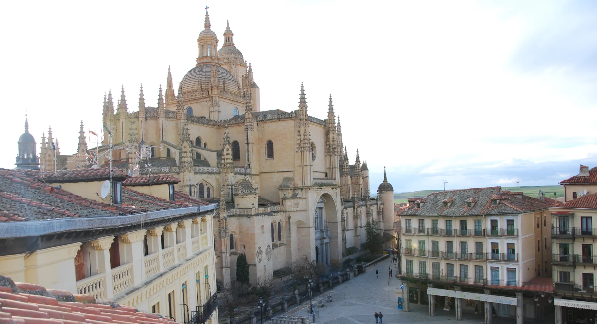 Catedral g&oacute;tica con c&uacute;pula y torres sobre tejados rojos, cielo despejado