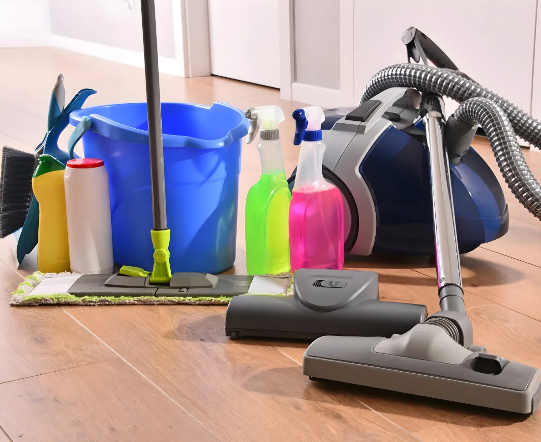Aspiradora y productos de limpieza en suelo de cocina con trapeador