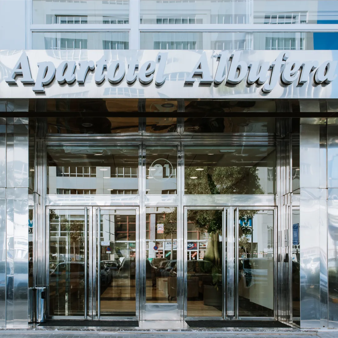Entrada del edificio &ldquo;Aparthotel Alberta&rdquo; con puertas de vidrio.