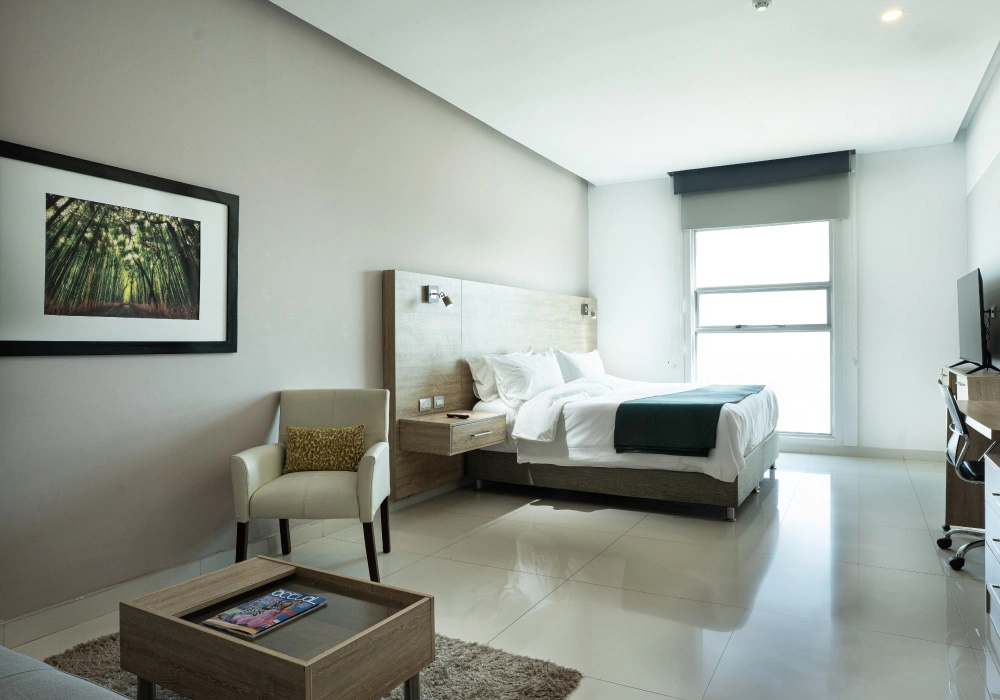 Dormitorio moderno con cama doble, silla y cuadro en la pared