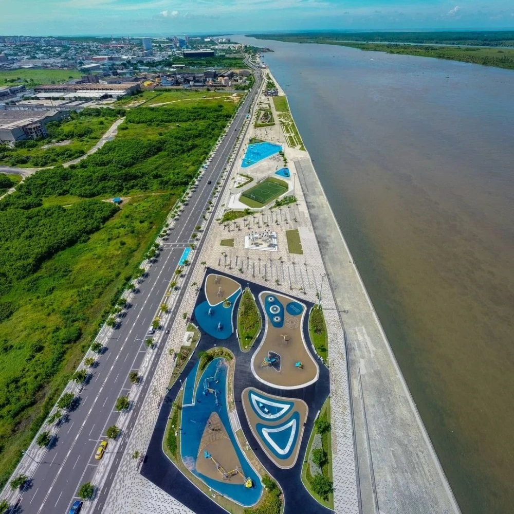 Vista a&eacute;rea de parque acu&aacute;tico con piscinas y avenida junto al r&iacute;o.