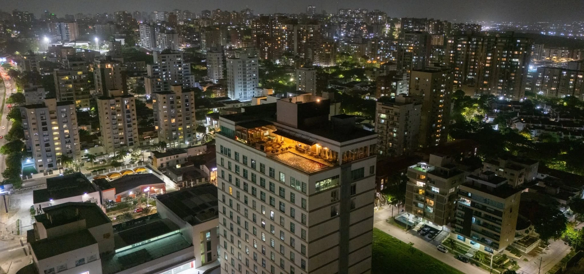 Vista nocturna de un edificio en medio de un barrio con luces urbanas