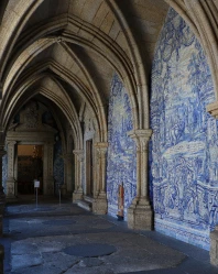Corredor g&oacute;tico com arcos e paredes azuis decoradas por pinturas