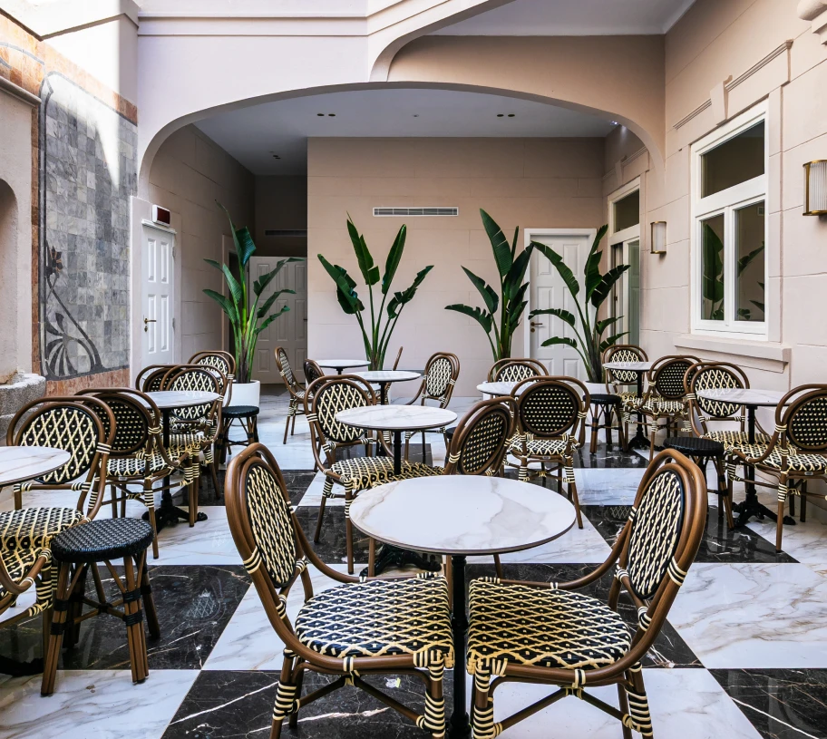 P&aacute;tio com mesas e cadeiras, plantas e piso de m&aacute;rmore em estilo cl&aacute;ssico