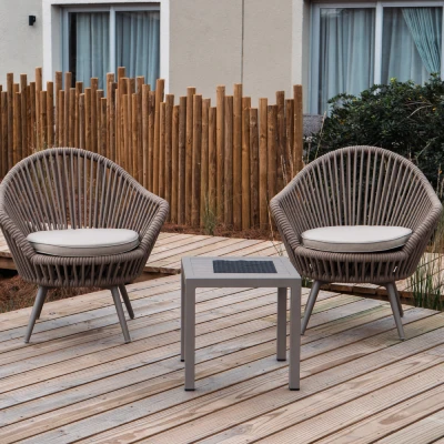 Dos sillones y mesa con cojines, terraza de madera y valla de bamb&uacute;.