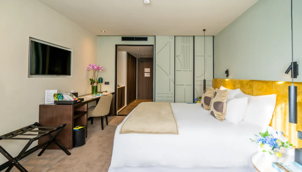 Habitaci&oacute;n de hotel con cama doble, escritorio y mampara decorativa