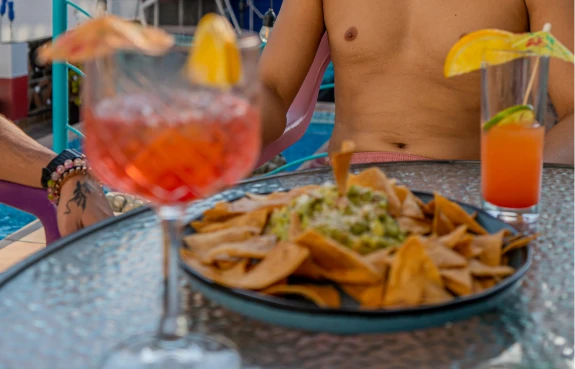 Hombre sentado en mesa con comida y limonada, vaso con bebida y cena.
