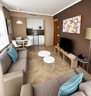 Sala de estar moderna con sof&aacute;, mesa, TV y cuadro en la pared