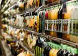 Estanter&iacute;a con botellas y productos en un supermercado, pasillo interior.