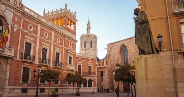 Plaza con edificios hist&oacute;ricos y estatua de bronce en Valencia, Espa&ntilde;a.