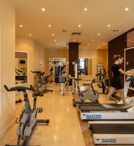 Sala de academia com esteiras, bicicletas ergom&eacute;tricas e aparelhos de muscula&ccedil;&atilde;o.