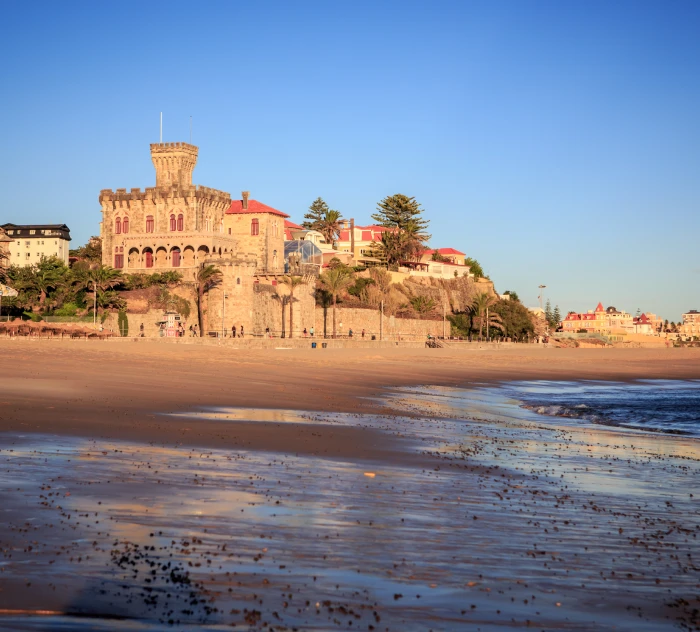 Forte hist&oacute;rico na praia de areia com c&eacute;u azul, ao p&ocirc;r do sol.
