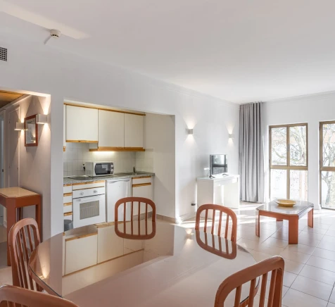 Cozinha moderna integrada &agrave; sala, com mesas e grandes janelas.