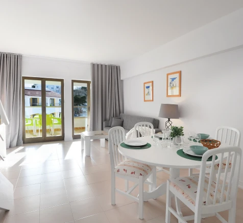 Sala de jantar com mesa branca, cadeiras, janelas e varanda ao fundo