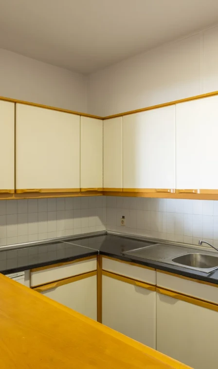 Cozinha planejada com arm&aacute;rios brancos e bancadas em canto, com pia e fog&atilde;o
