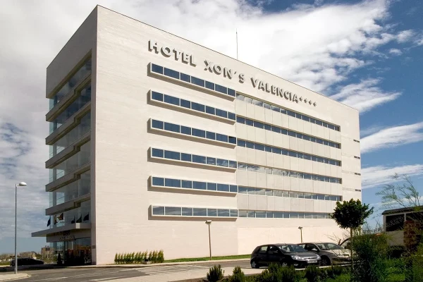 Hotel H10 Val&egrave;ncia, fachada blanca con ventanas y cielo nublado