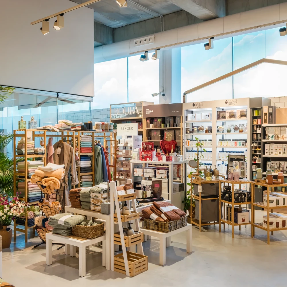 Tienda de accesorios y velas con estantes y textiles en un espacio moderno
