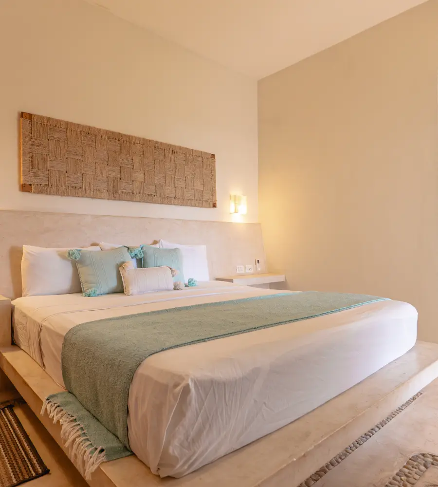 Dormitorio moderno con cama doble, colcha verde y panel de pared tejido