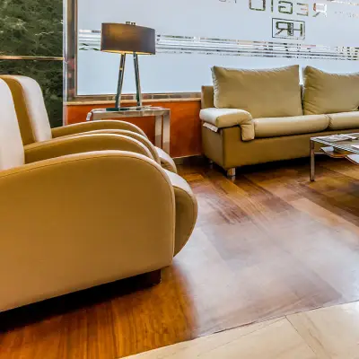 Sala de estar con sof&aacute; beige, sillones y mesa auxiliar cerca de ventana