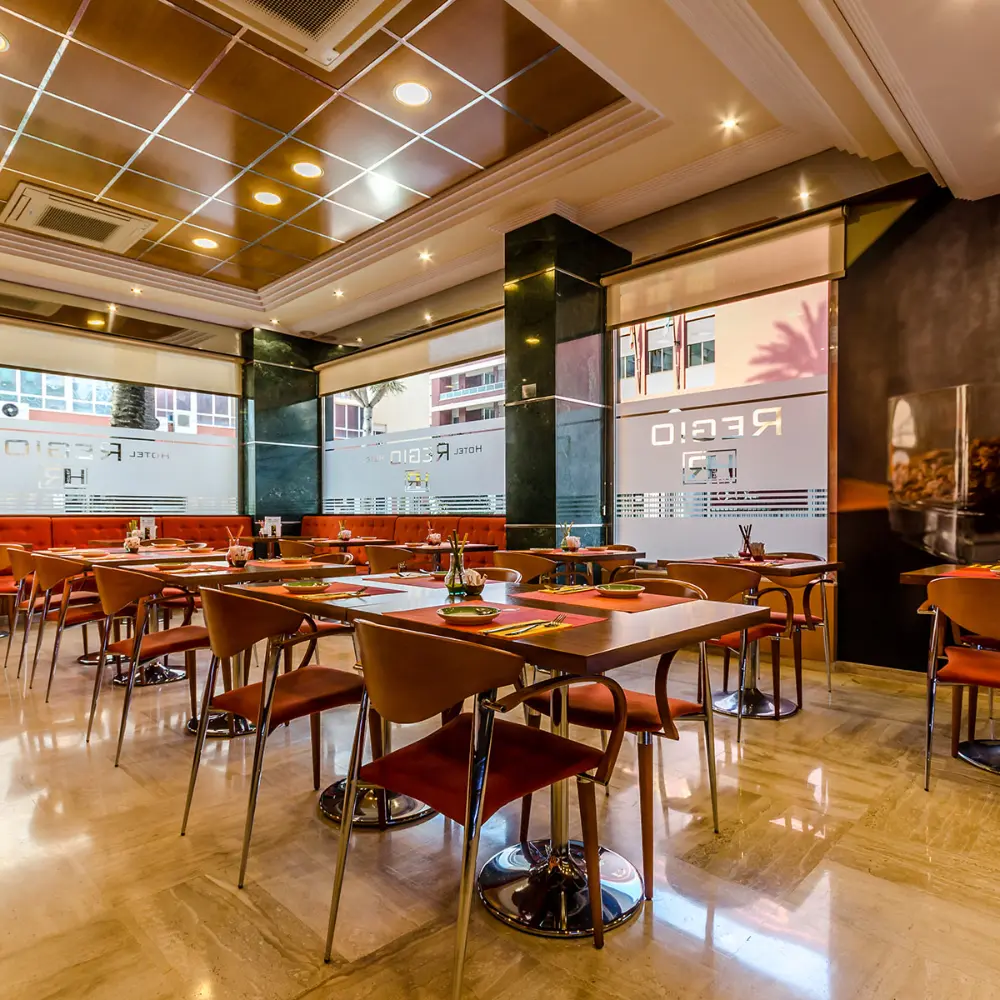 Interior de restaurante moderno con mesas, sillas y luces empotradas