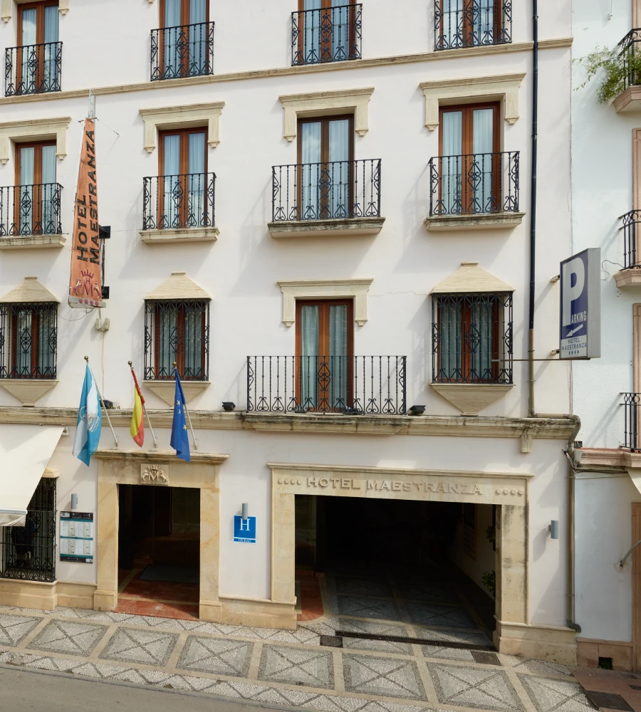Fachada del Hotel Maestranza con banderas y ventanas con rejas, exterior urbano