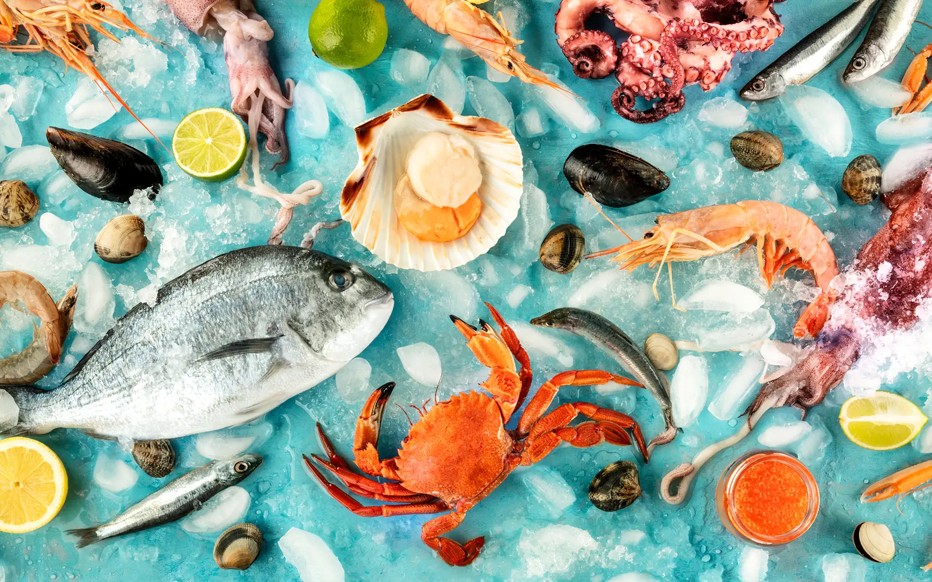 Mariscos y pescados sobre hielo con lim&oacute;n, almejas, cangrejo y gambas en azul.