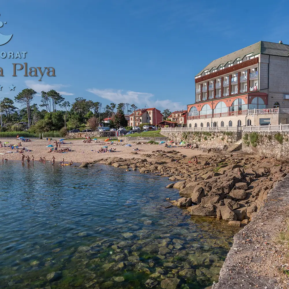 Playa con rocas, agua transparente y hotel frente a la costa al cielo azul