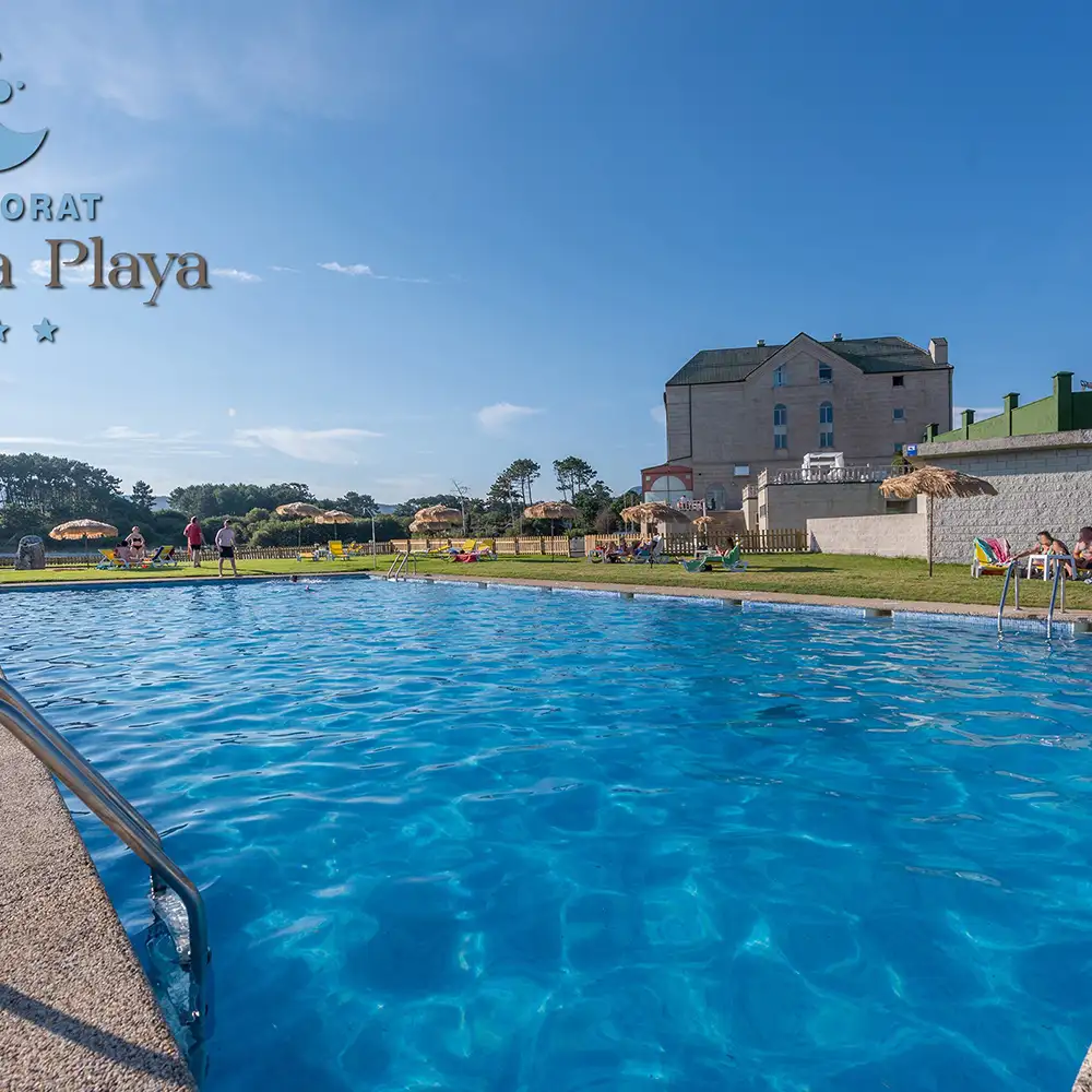 Piscina azul con edificio y personas en la playa de resort bajo el sol